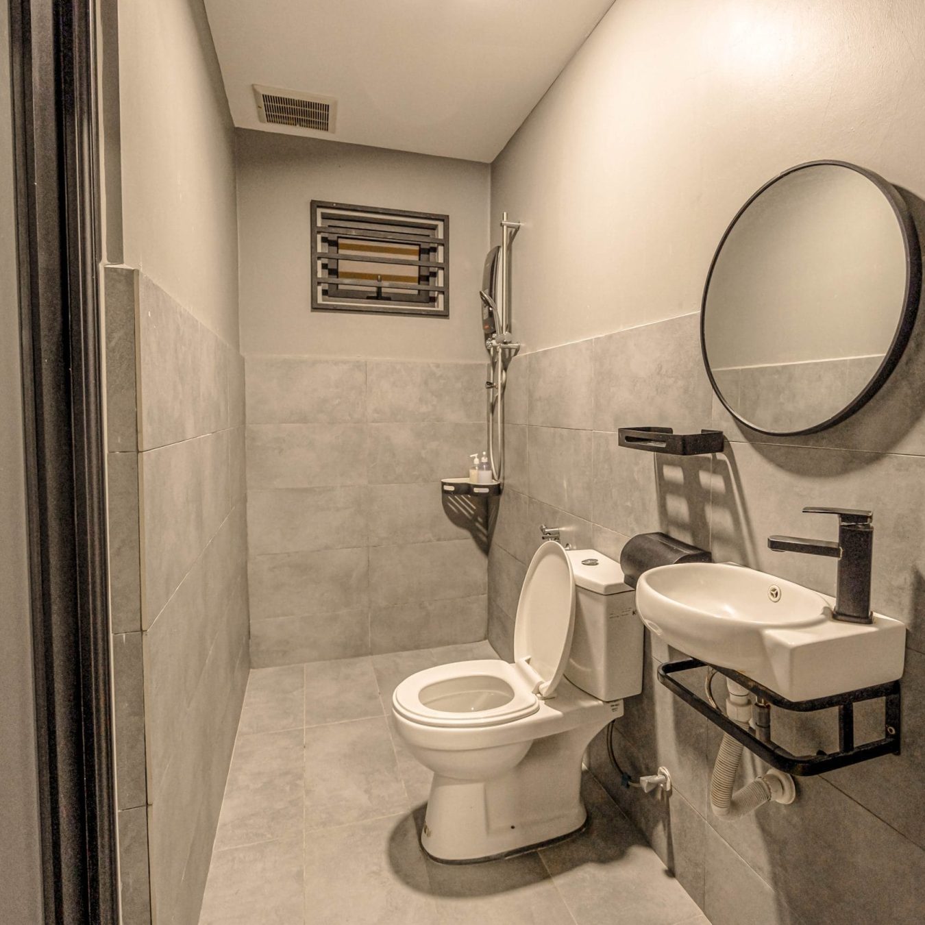 Modern industrial style ensuite bathroom with water heater and bidet at Le's Homestay Lot 916