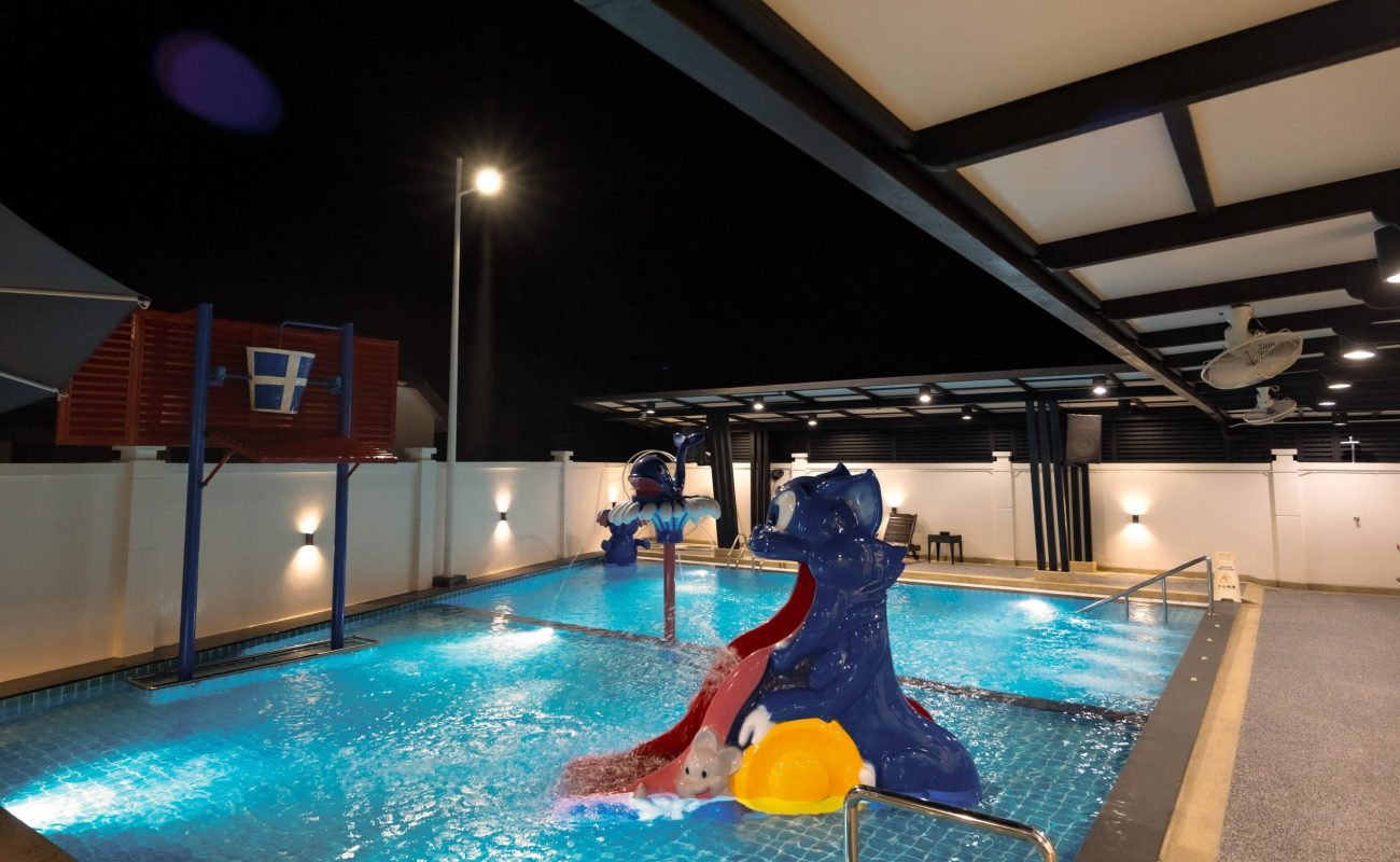 Night view of private swimming pool with water slide and basketball hoop at Le's Homestay Lot 916