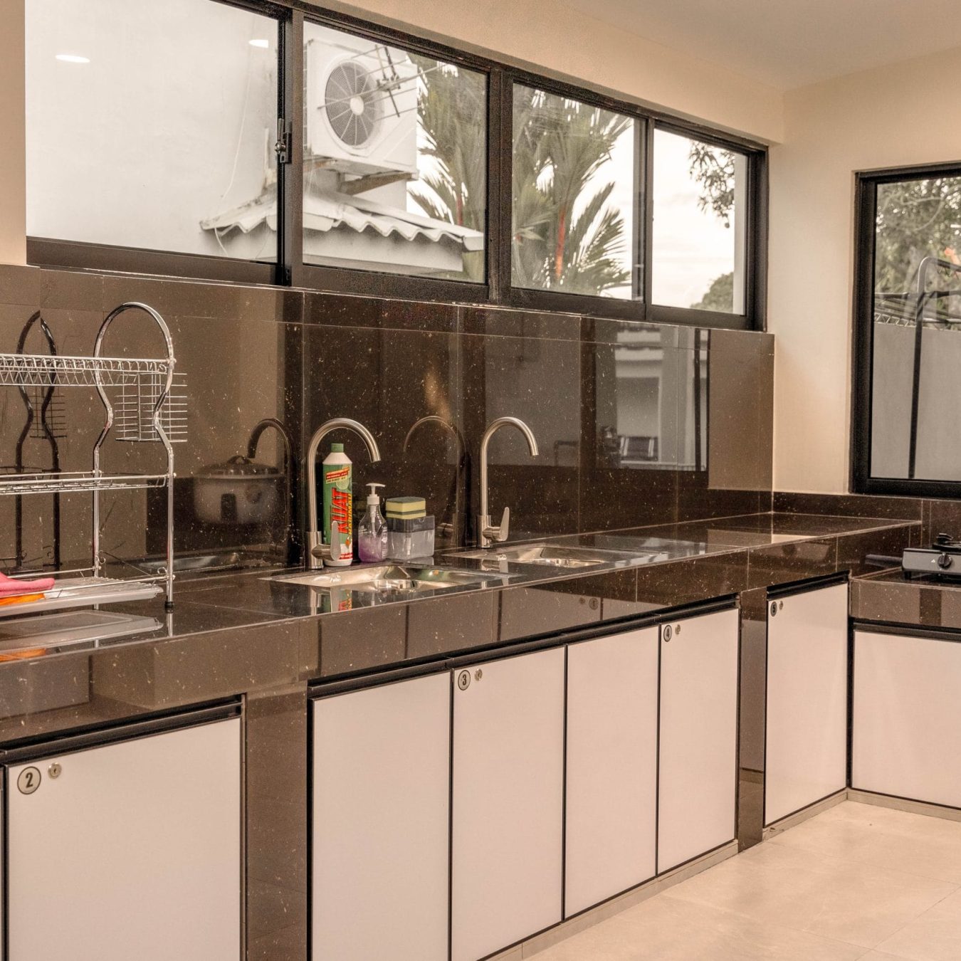 Fully equipped kitchen area with sink and cabinets at Le's Homestay