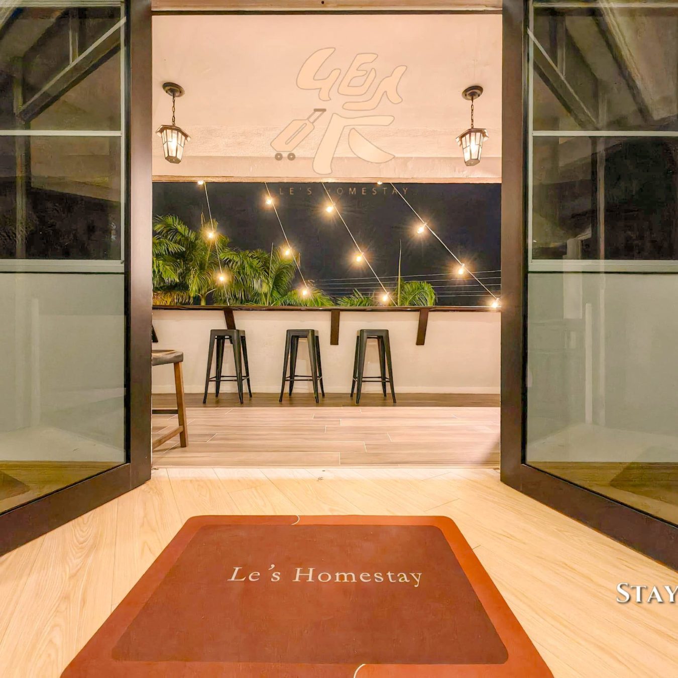 Entrance patio with bar seating and welcome mat at Le's Homestay