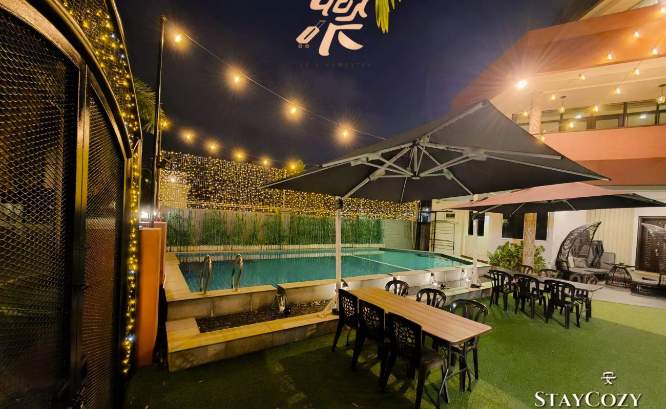 Outdoor garden dining area by the pool at night at Le's Homestay Lot 550, a spacious Homestay Melaka Private Pool unit.