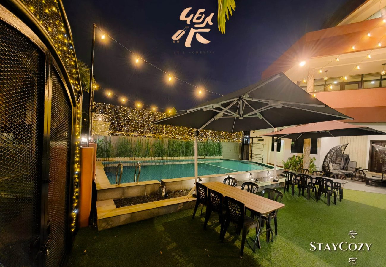 Outdoor garden dining area by the pool at night at Le's Homestay Lot 550, a spacious Homestay Melaka Private Pool unit.